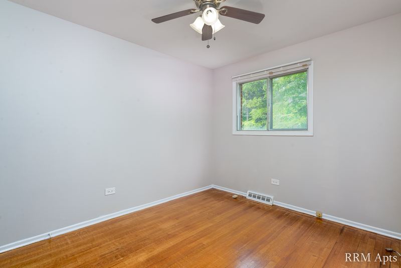 Bedroom with wood floor, ceiling fan and a window on the far wall, Westerfield Place apartment 149 A
