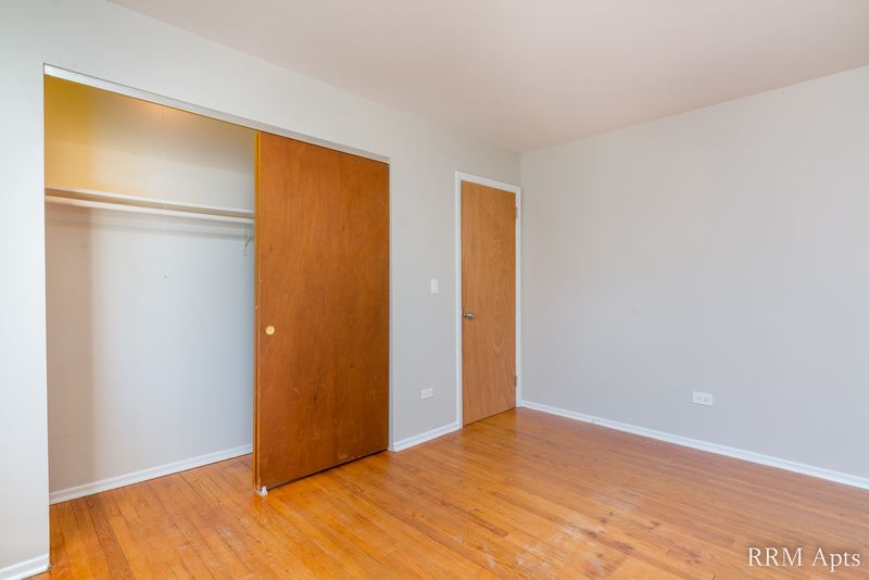 Bedroom with wood floor, closet with wood sliding doors and a doorway, Westerfield Place apartment 149-C